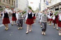 Dejojošie un dziedošie skolēni ņipri dodas dziesmu svētku gājienā